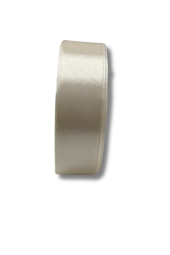 A 25mm-wide, cream Satin Ribbon from Super Cheap Fabrics, with a slight sheen, is shown upright against a white background and soft shadow. One of 16 colours available.