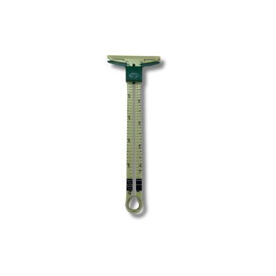 A green and black Sliding Sewing Gauge by Super Cheap Fabrics, resembling a precise caliper, rests on a plain white background.