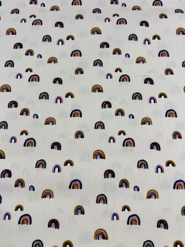 Super Cheap Fabrics' Printed Canvas - Wanderlust - 112cm features small, colorful rainbows on a white background, ideal for crafting cotton tote bags or adding whimsy to home décor.