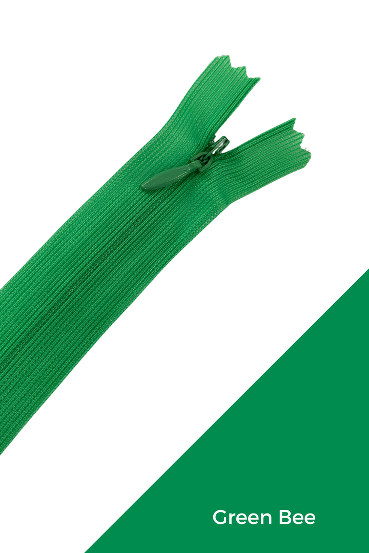 A 30cm green Invisible Zip from Super Cheap Fabrics, made of polyester, is shown partly unzipped and placed diagonally on a white background with a green triangle in the lower right corner. "Green Bee" appears in white text on the green section.