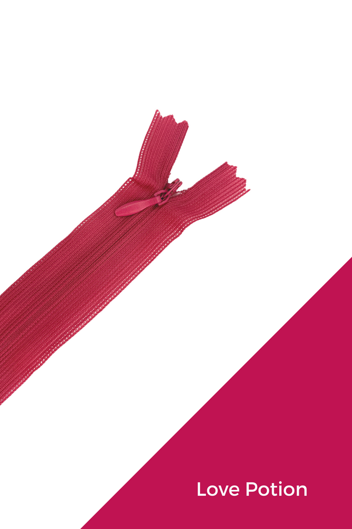 A Super Cheap Fabrics Invisible Zip - 30cm - Pinks & Reds lies diagonally on a white background, with a magenta lower right corner displaying "Love Potion" in white text.