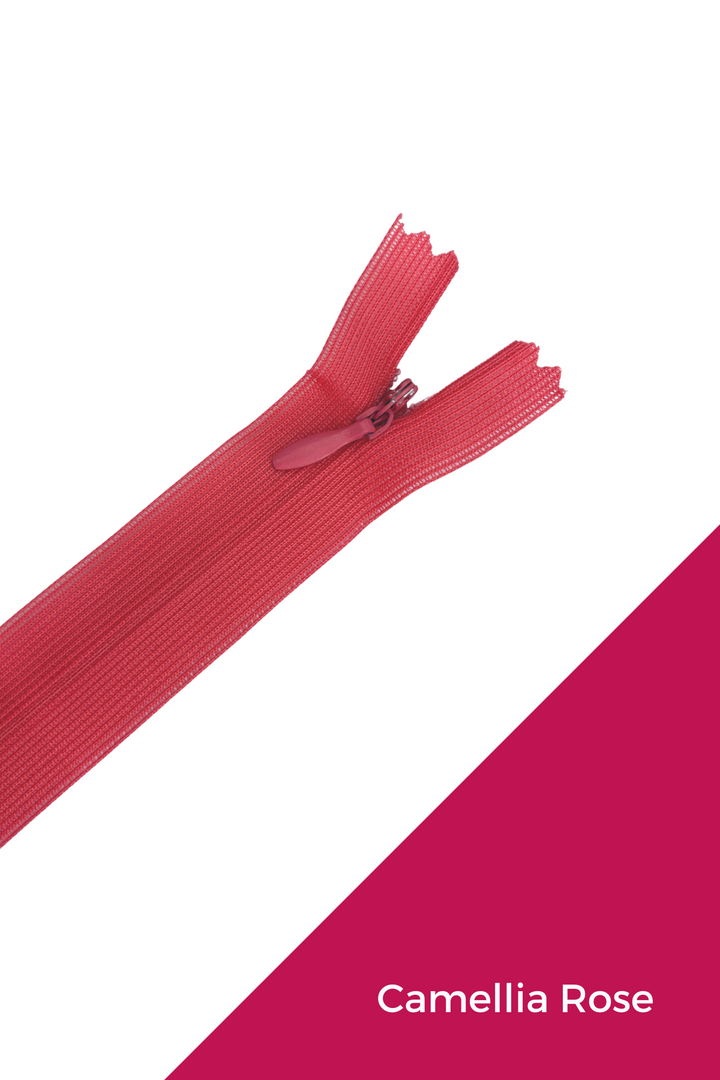A close-up of the Super Cheap Fabrics Invisible Zip - 30cm - Pinks & Reds, shown on a white and dark pink background, with "Camellia Rose" text in the bottom right corner.
