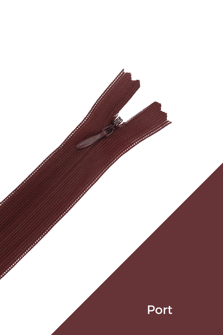 A 30cm Invisible Zip in pinks & reds by Super Cheap Fabrics is displayed diagonally on a white background, with a bottom corner showing matching brown fabric labeled "Port.