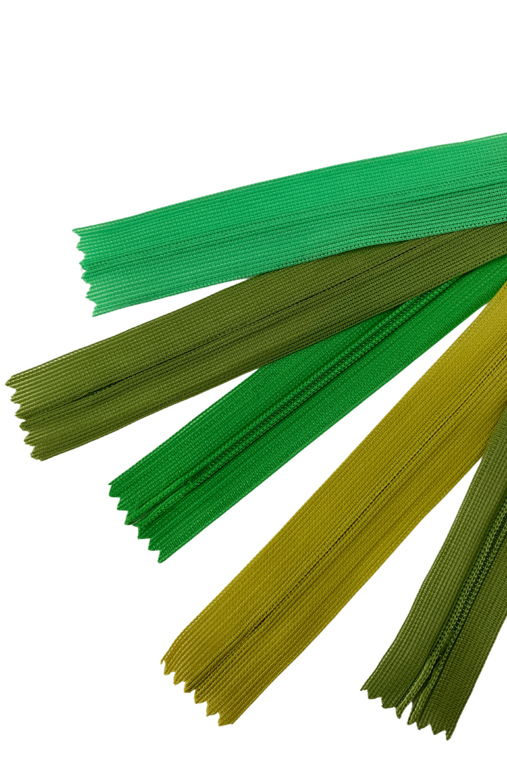 Several Super Cheap Fabrics Invisible Zip – 30cm – Greens are fanned out on a white background, showing varying green shades.