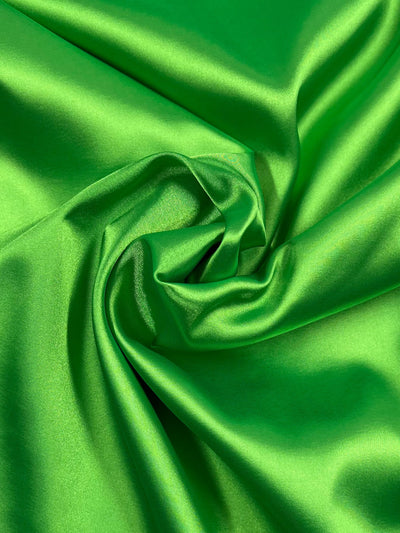 Satin Deluxe - Jasmine Green by Super Cheap Fabrics is a shiny, vibrant stretch satin (150cm wide), with softly gathered folds that create a smooth, luxurious look—perfect for lightweight dresses.